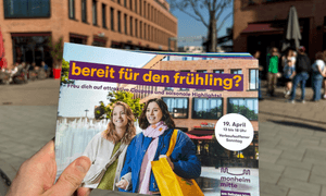 Eine Hand hält das Couponheft fest.